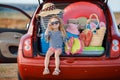 Happy baby girl sitting in the car trunk Royalty Free Stock Photo