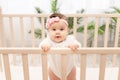 Happy baby girl six months standing in the crib Royalty Free Stock Photo