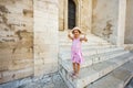 Happy baby girl tourist show thumbs up against Basilica of Saint Nicholas in Bari, Puglia, South Italy Royalty Free Stock Photo