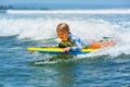 Little child swimming with bodyboard on the sea waves Royalty Free Stock Photo