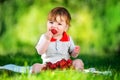 Happy baby have fun in the Park on a Sunny meadow with strawberry. Summer vacation concept. The emotions. Royalty Free Stock Photo
