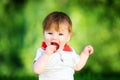 Happy baby have fun in the Park on a Sunny meadow with strawberry. Summer vacation concept. The emotions. Royalty Free Stock Photo