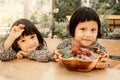 Happy baby and kid wearing twin clothes sitting on the table with a plate of grapes freeze in ice, eat healthy fruit childhood Royalty Free Stock Photo