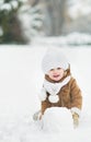 Happy baby making snowball for snowman