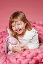 Happy baby on pink coral background looks up in surprise. Royalty Free Stock Photo