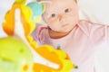 Happy baby playing with children's musical mobile toy Royalty Free Stock Photo