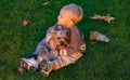 Happy baby playing with little dog at autumnal nature. Sunny autumn day. Outdoor portrait of cute baby. Cute little