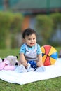 Happy baby playing outdoors with colourful ball