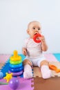 Happy baby is playing with a toy pyramid. Educational toys for toddlers Royalty Free Stock Photo