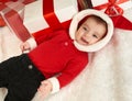 Happy baby portrait in christmas decoration, lie on fur near fir tree and gifts, winter holiday concept Royalty Free Stock Photo