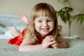 Happy baby portrait.emotional baby girl on the bed in a bright bedroom. cozy white room, cheerful child. emotionally screams, Royalty Free Stock Photo