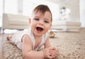 Happy, baby portrait and tummy time on floor, laugh and play in living room. Teething, child development and growth Royalty Free Stock Photo