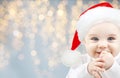 Happy baby in santa hat over holidays lights Royalty Free Stock Photo