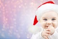 Happy baby in santa hat over holidays lights Royalty Free Stock Photo