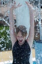 Cheerful girl at the fountain in the water park