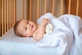 Happy baby waking up after sleeping, holding toy Royalty Free Stock Photo