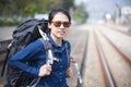 Happy backpacker asian woman in casual dress and bag on,wait for the railway train at station Royalty Free Stock Photo