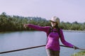 Happy backpacking woman standing with hands pointing something and looking beautiful view at outdoor