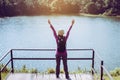 Happy backpacking woman standing with hands raise up and looking beautiful view at outdoor