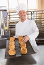 Happy baker holding tray of fresh bread Royalty Free Stock Photo