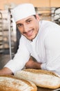 Happy baker holding tray of fresh bread Royalty Free Stock Photo