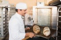 Happy baker holding tray of fresh bread Royalty Free Stock Photo