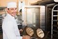 Happy baker holding tray of fresh bread Royalty Free Stock Photo