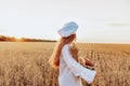 A happy baker holding a wicker basket in her hands, with a wheat field in the background Royalty Free Stock Photo