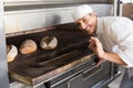 Happy baker by open oven Royalty Free Stock Photo