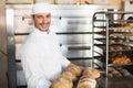 Happy baker showing tray of fresh bread Royalty Free Stock Photo