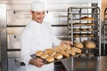 Happy baker showing tray of fresh bread Royalty Free Stock Photo