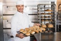 Happy baker showing tray of fresh bread Royalty Free Stock Photo