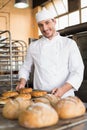 Happy baker taking out fresh bagels