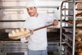 Happy baker taking out fresh loaf Royalty Free Stock Photo