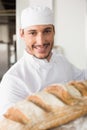 Happy baker taking out fresh loaf Royalty Free Stock Photo