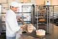 Happy baker taking out fresh loaf