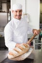 Happy baker taking out fresh loaf Royalty Free Stock Photo