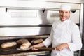 Happy baker taking out fresh loaf Royalty Free Stock Photo