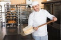 Happy baker taking out fresh loaf Royalty Free Stock Photo