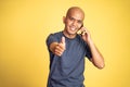 Happy bald man showing thumbs up listening to mobile phone Royalty Free Stock Photo