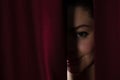 Ballet dancer peeking through a stage curtain Royalty Free Stock Photo