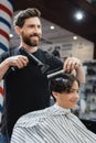Happy barber drying hair of smiling