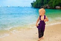 Happy barefoot child in loose jumpsuit on tropical sea beach