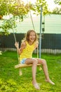 Happy barefoot laughing child girl swinging on a swing in sunset summer day Royalty Free Stock Photo