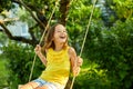 Happy barefoot laughing child girl swinging on a swing in sunset summer day Royalty Free Stock Photo