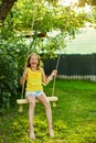 Happy barefoot laughing child girl swinging on a swing in sunset summer day Royalty Free Stock Photo