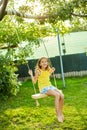 Happy barefoot laughing child girl swinging on a swing in sunset summer day Royalty Free Stock Photo