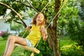 Happy barefoot laughing child girl swinging on a swing in sunset summer day Royalty Free Stock Photo