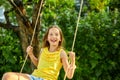 Happy barefoot laughing child girl swinging on a swing in sunset summer day Royalty Free Stock Photo