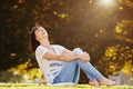 Happy barefoot woman sitting on grass in park Royalty Free Stock Photo